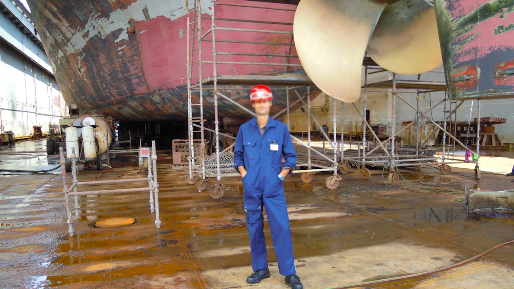 Ein Arbeiter vor einem kommerziellen Seeschiff als Symbol für ausländische Seeleute
