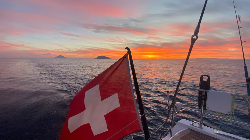 Le pavillon suisse sur la mer devant le volcan de Stromboli. 