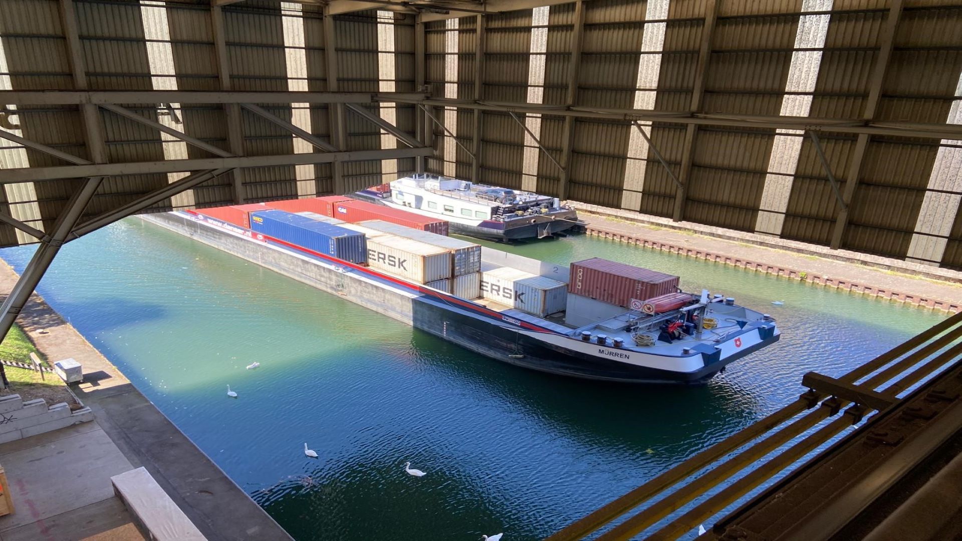 Un bateau chargé de conteneurs navigant sur le Rhin.